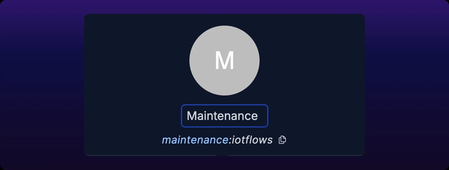 The top of a team page. A large circular team avatar lettered M sits above the team name, open as an editable text field holding Maintenance with the cursor in it, and below that the handle reads maintenance:iotflows with a copy button to its right
