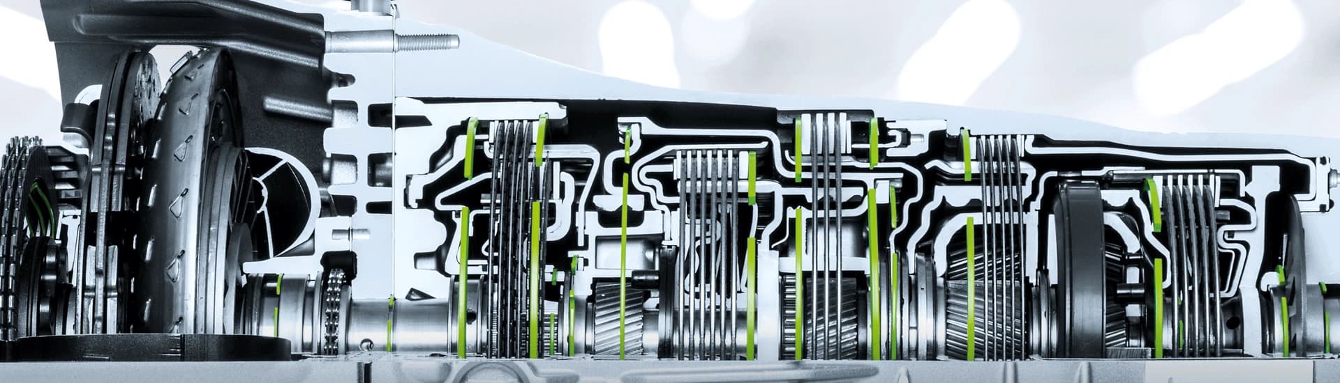 A cross-section of a car transmission, with Benzing rings highlighted in green throughout its clutch packs and gear sets